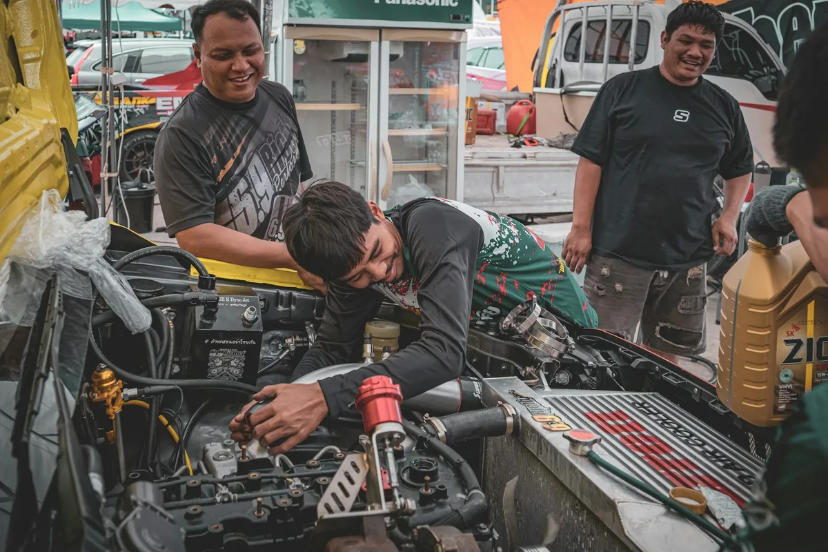 Mecânico inspecionando motor de carro em oficina