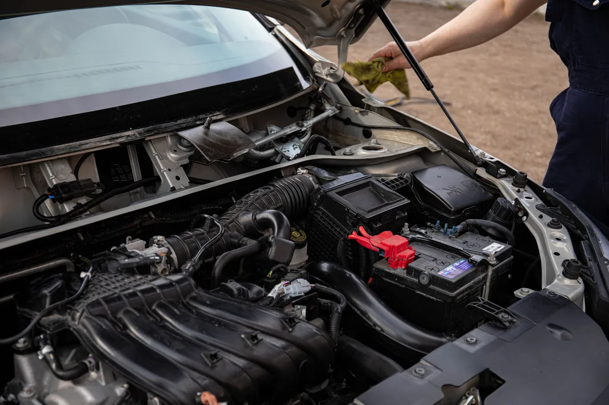 Mecânico inspecionando o motor de um carro para diagnosticar falha