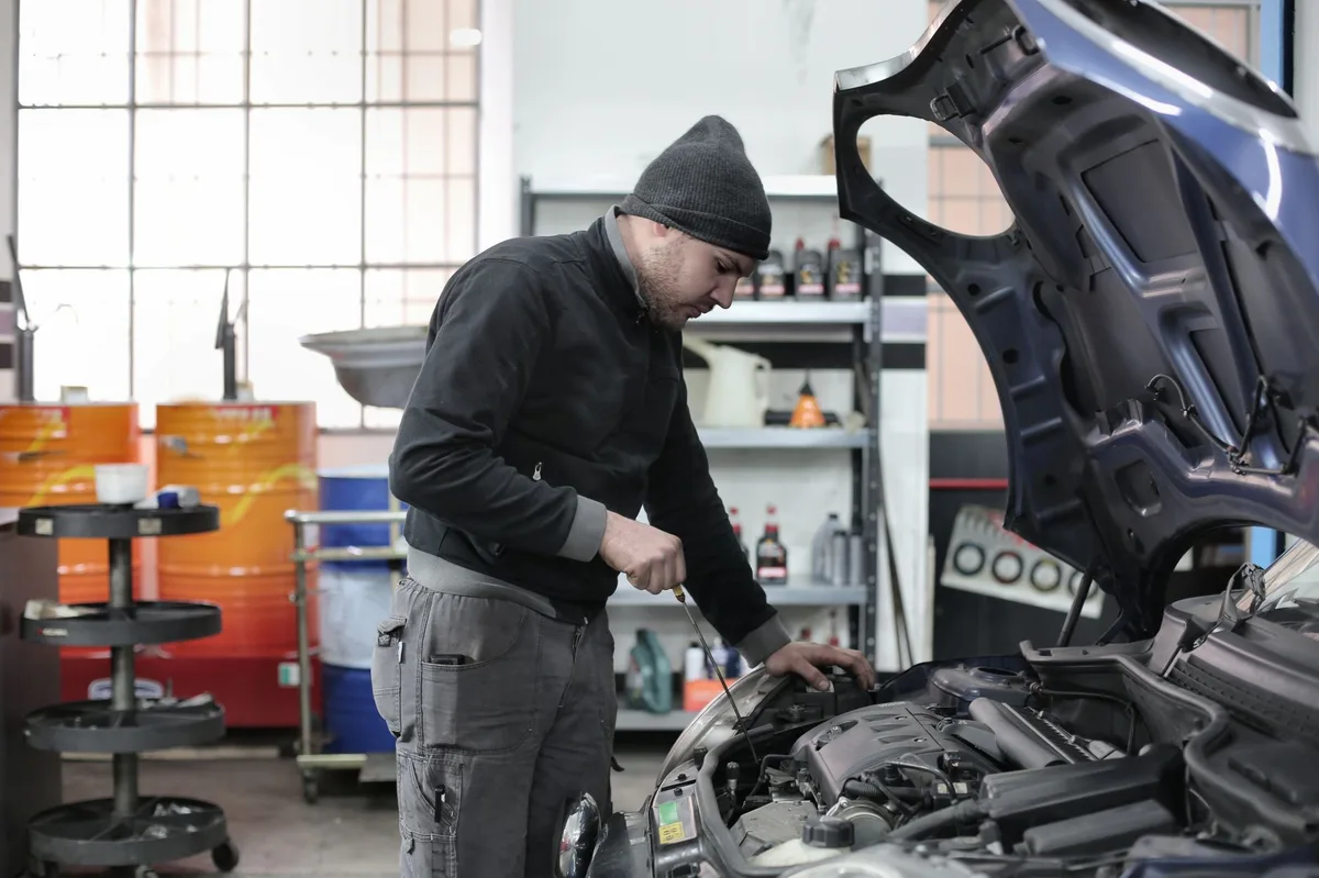 Mecânico trabalhando sob o carro verificando sistema de direção