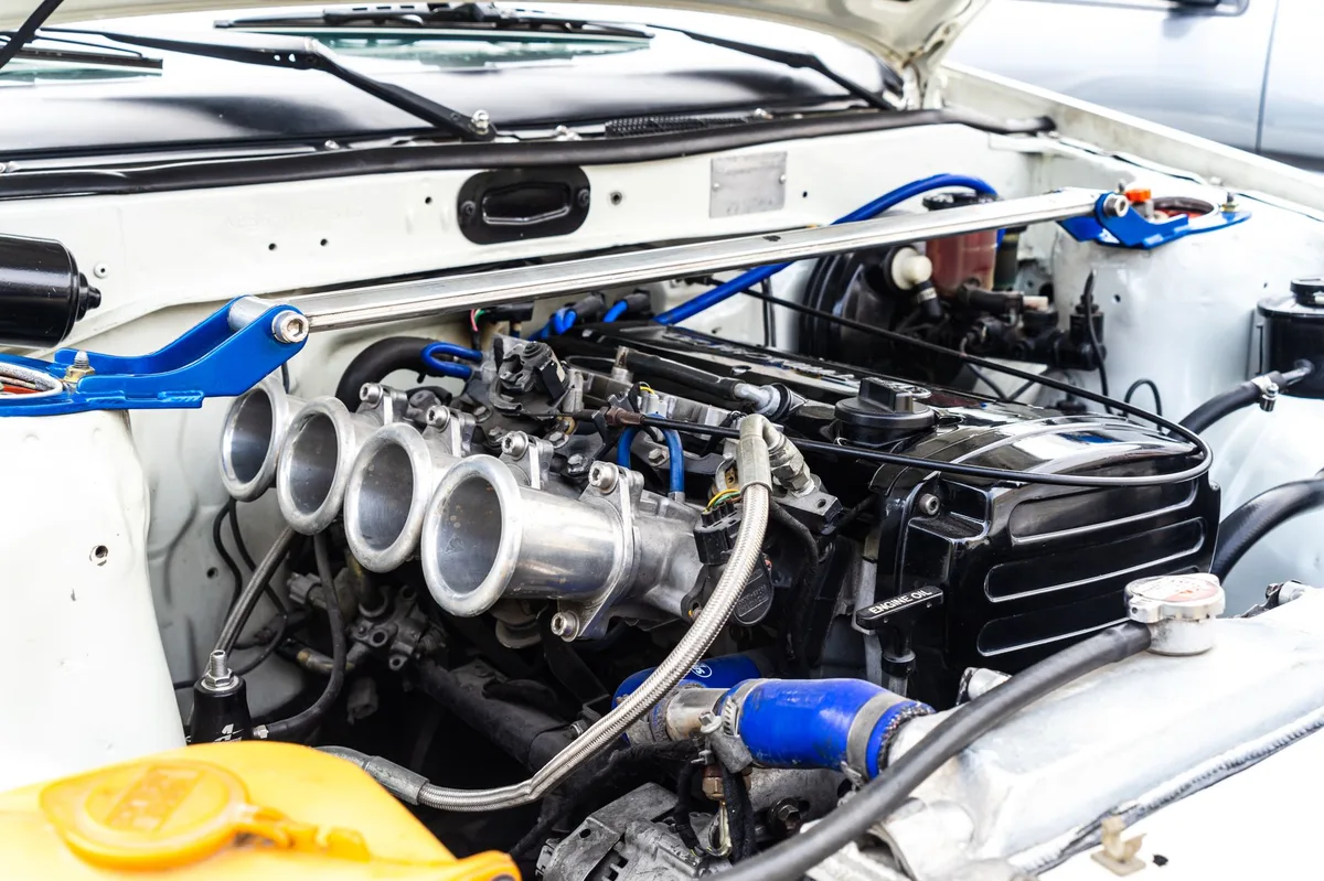 Close do motor de um carro mostrando componentes do sistema de combustível