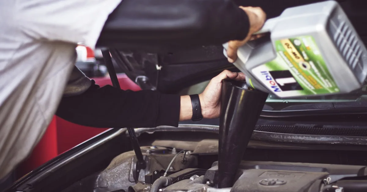 Pessoa adicionando óleo novo no motor de um carro com capo aberto