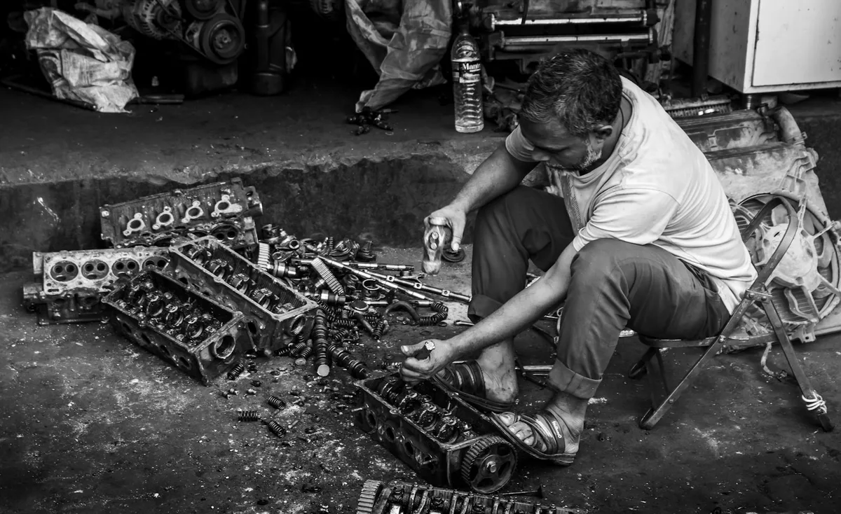 Mecânico realizando troca de óleo do motor em oficina