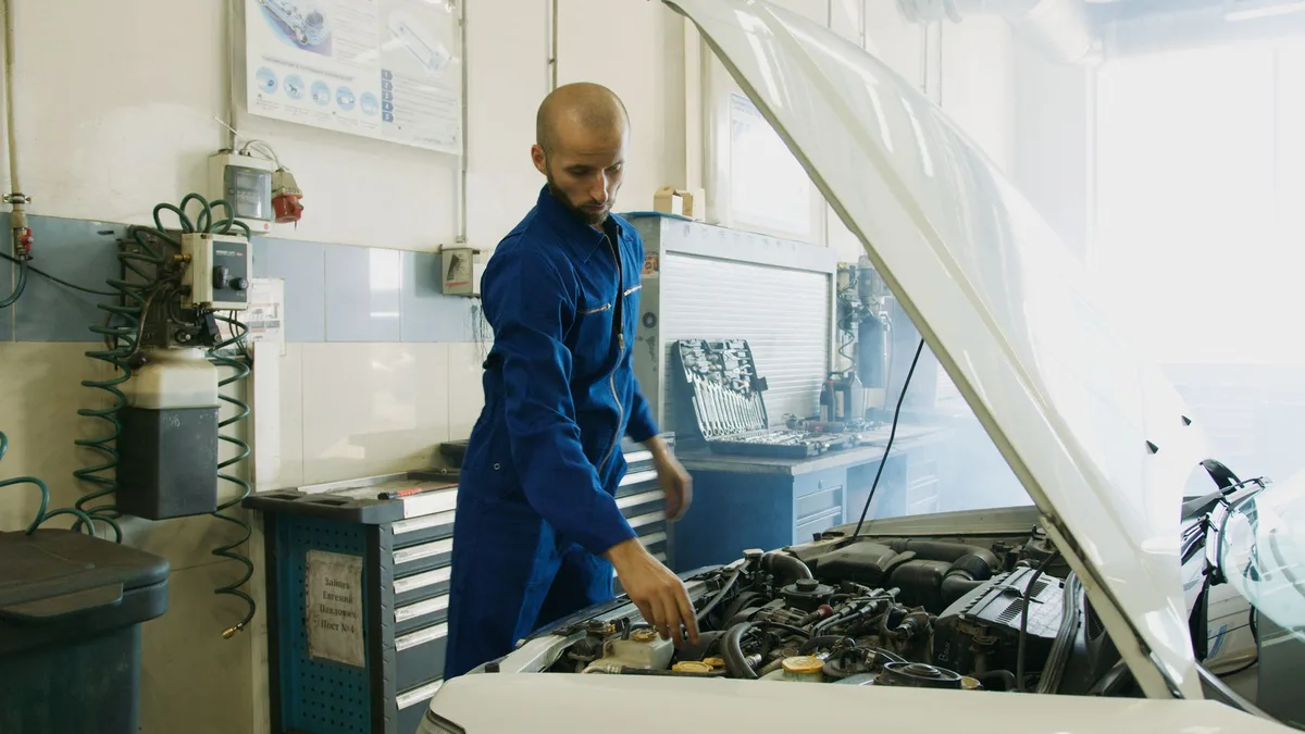 Mecânico inspecionando motor de carro em oficina