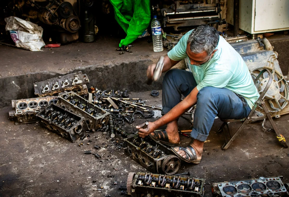 Mecânico inspecionando o motor de um veículo em oficina automotiva